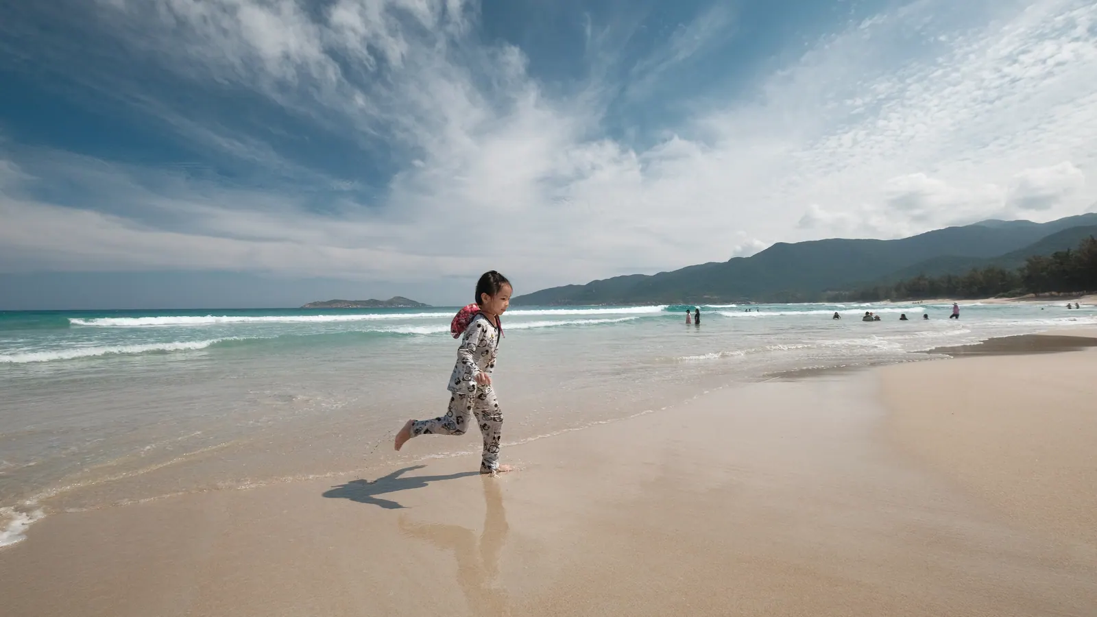 Wide, empty sand at Bai Dai near Cam Ranh with a child running along the beach
