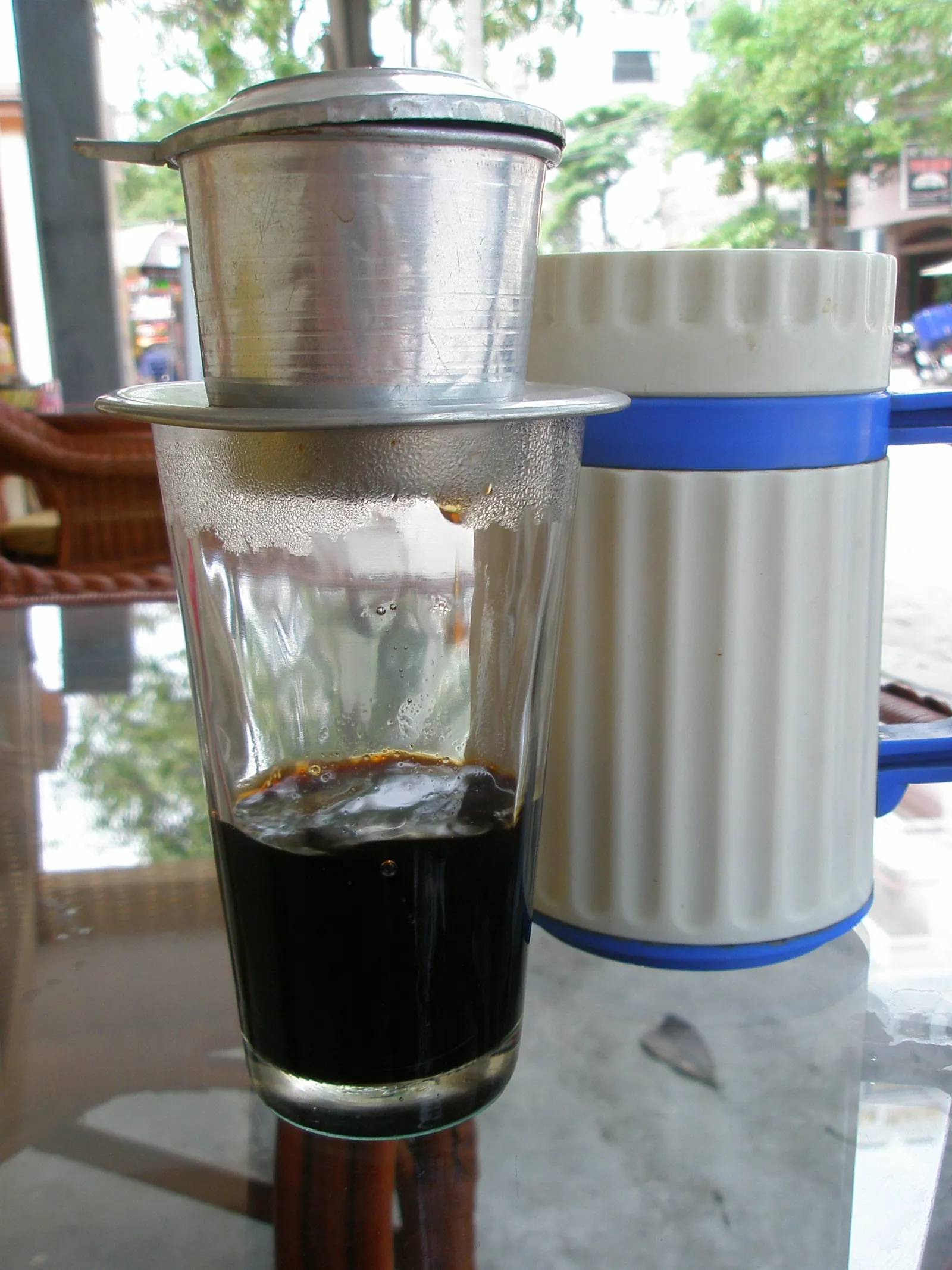 Hot Vietnamese coffee brewing in a metal drip filter in Nha Trang