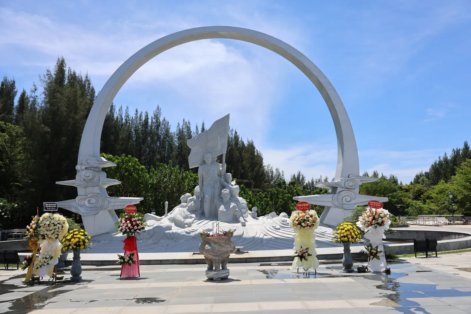 The Gac Ma memorial at Bai Dai, Cam Lam: a white sculpture of soldiers beneath a great circle, with flowers laid in front